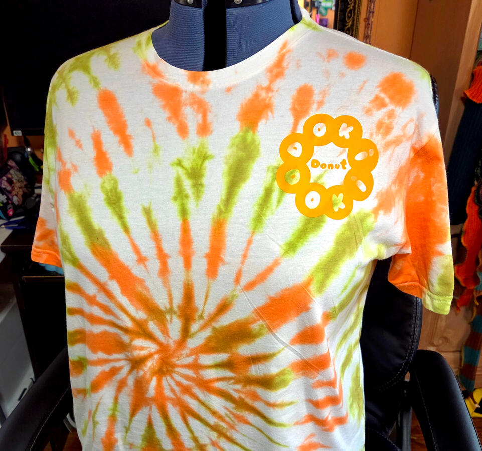 "Doki Doki Donut" FRONT. Original Design for a self-created fictional shop. example in size XL. low immersion tie-dye in-house; self-designed DTF outsourced for print and aplied in-house.